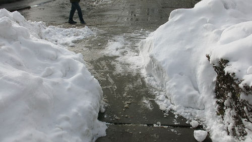 A wider, mostly clean passage between two snow piles.