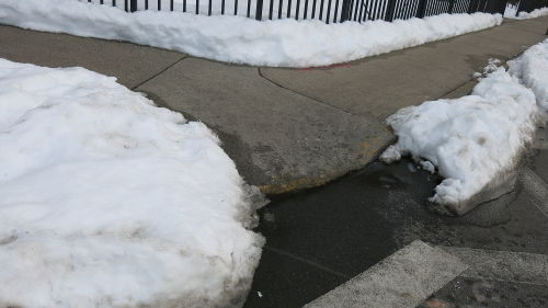 Snow piled up at a street corner.